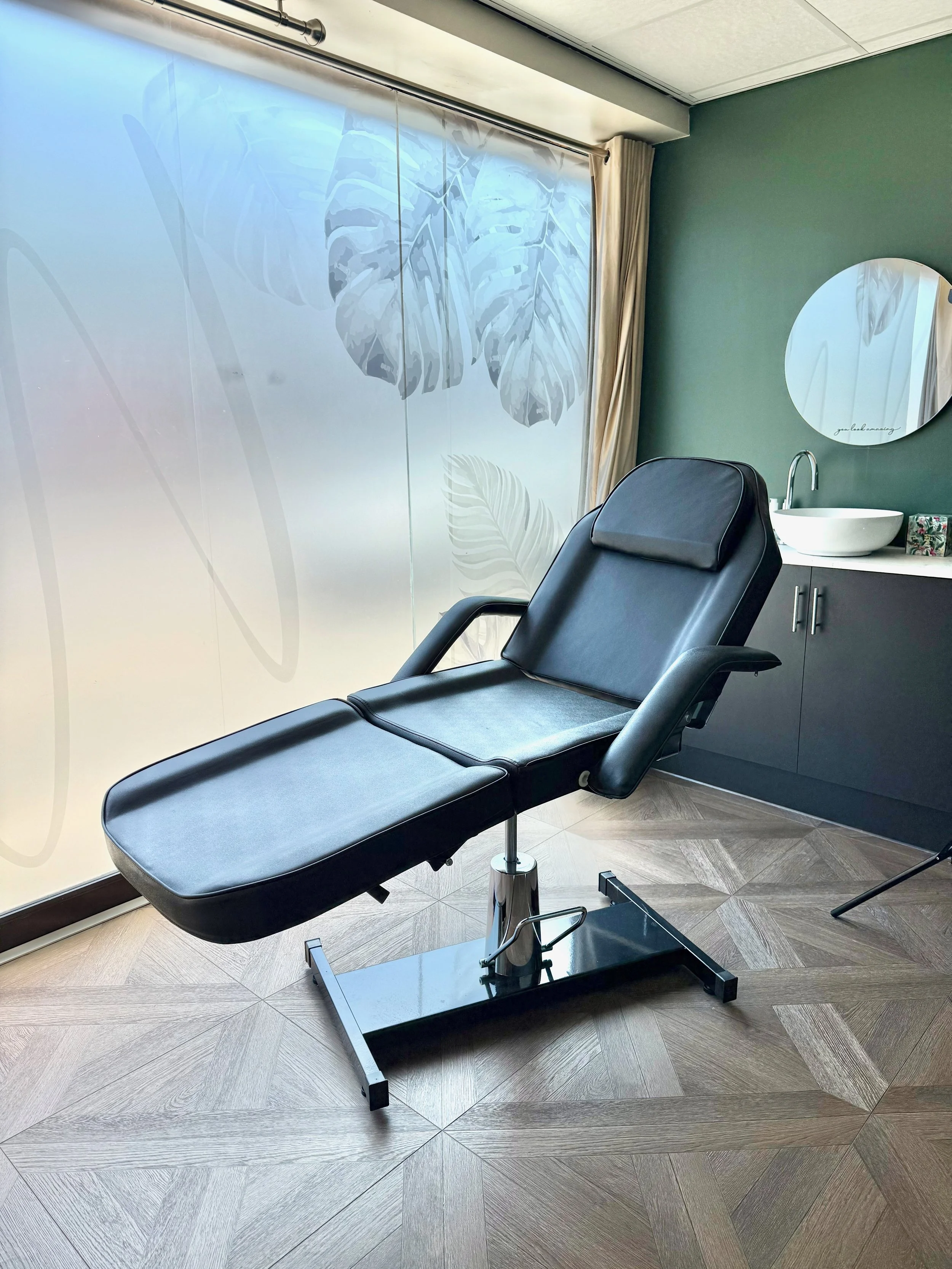 A reclining treatment chair in a softly lit room at The Wellness Lounge Leeds