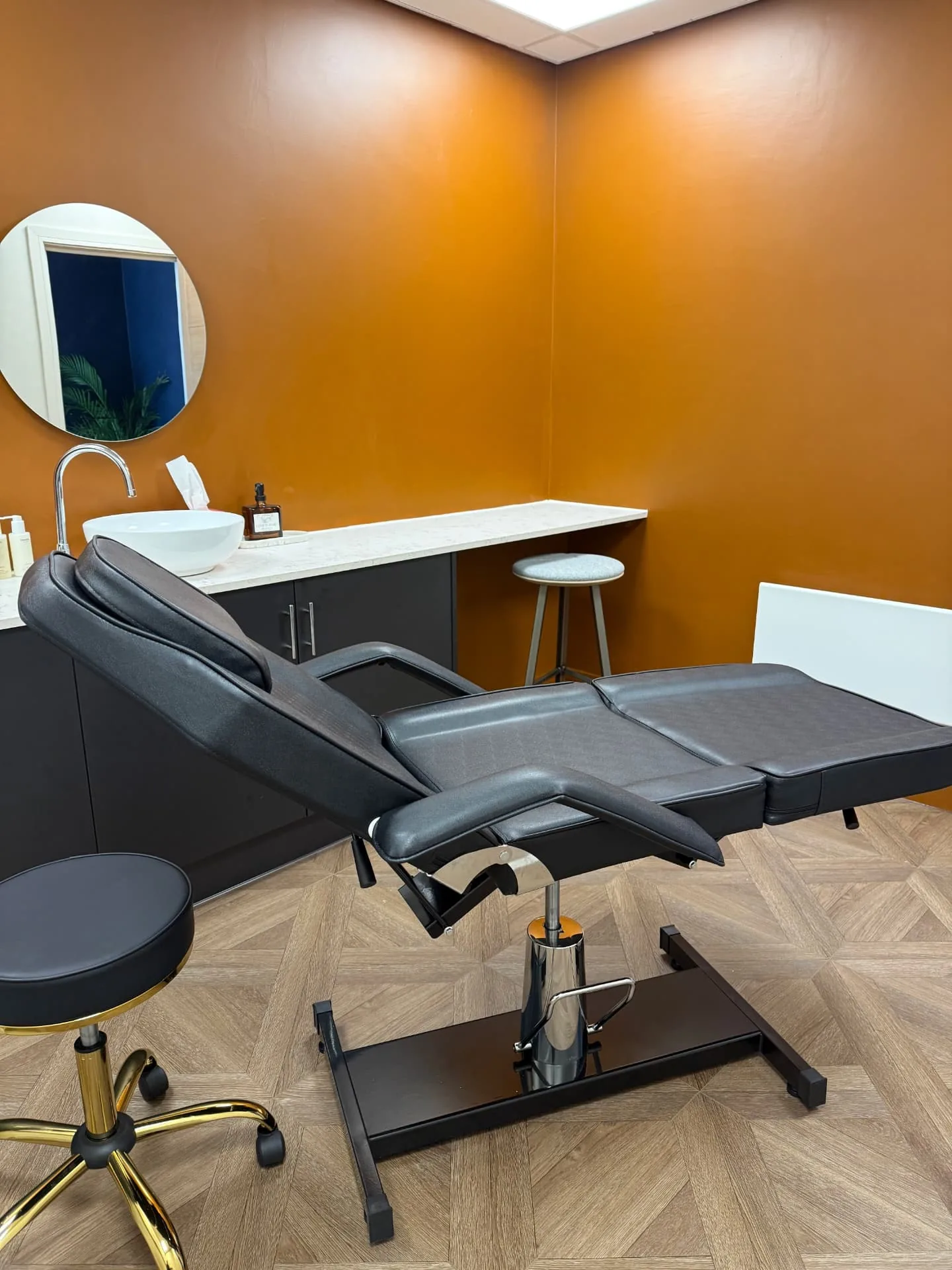 The Beech Room at The Wellness Lounge Leeds with a reclining treatment couch, basin and round mirror
